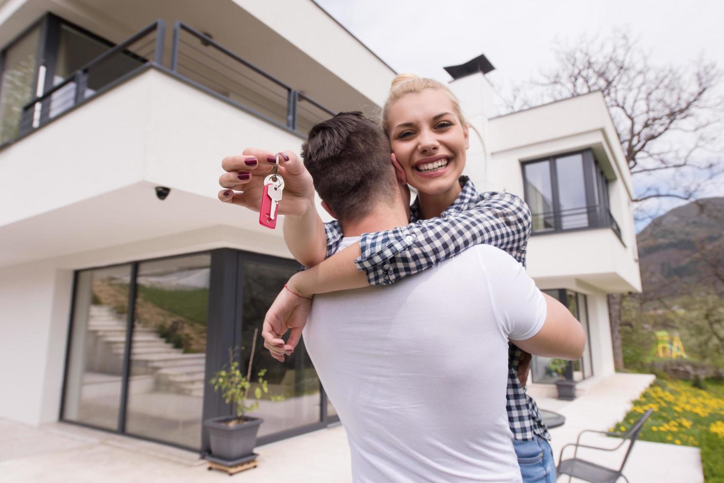 couple hugging in front of  new luxury home photo