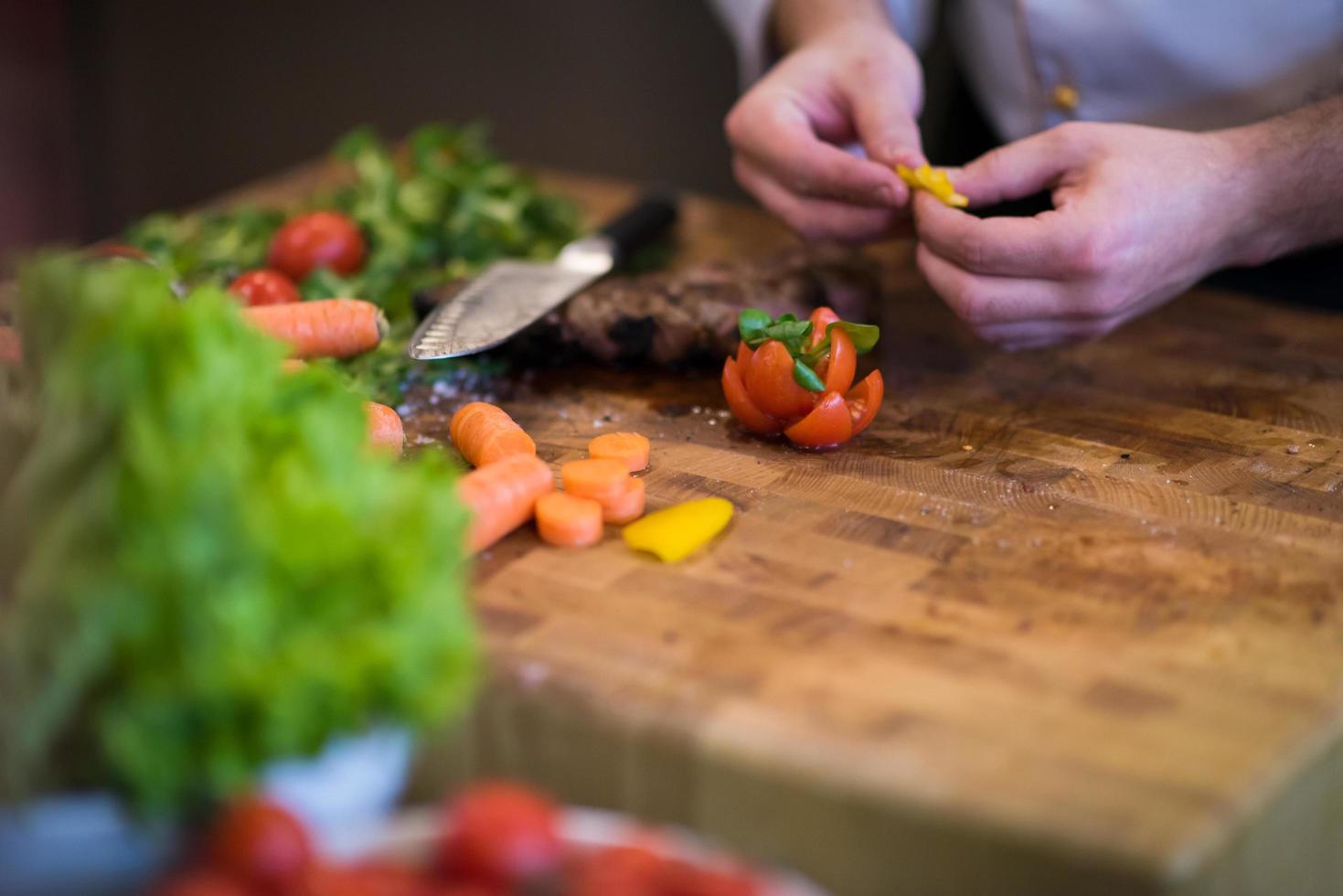 primer plano de las manos del chef preparando bistec de ternera foto