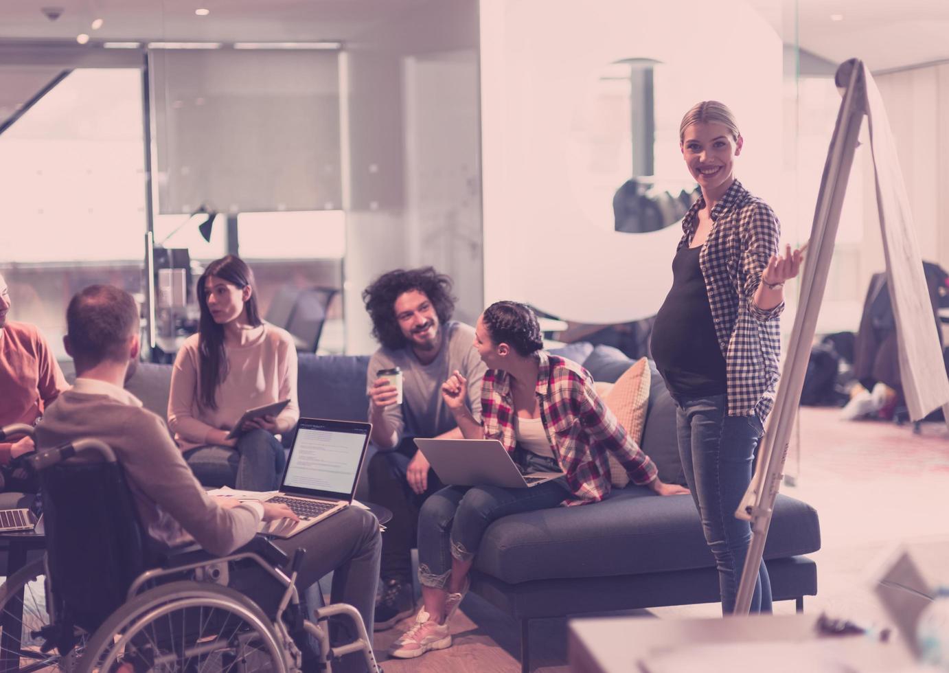 mujer de negocios embarazada lidera una reunión creativa del equipo de negocios en una moderna oficina de espacio abierto de coworking foto