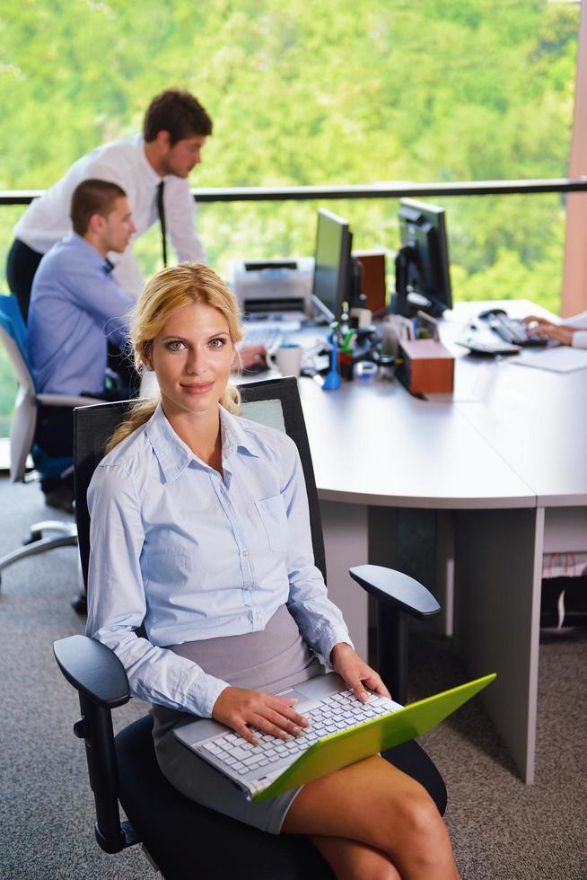 business woman with her staff in background at office photo