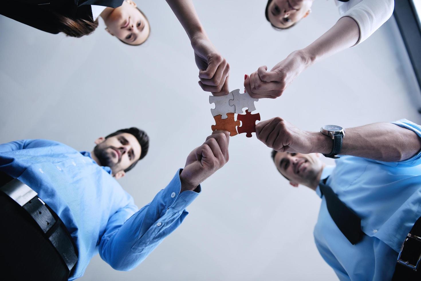 Group of business people assembling jigsaw puzzle photo