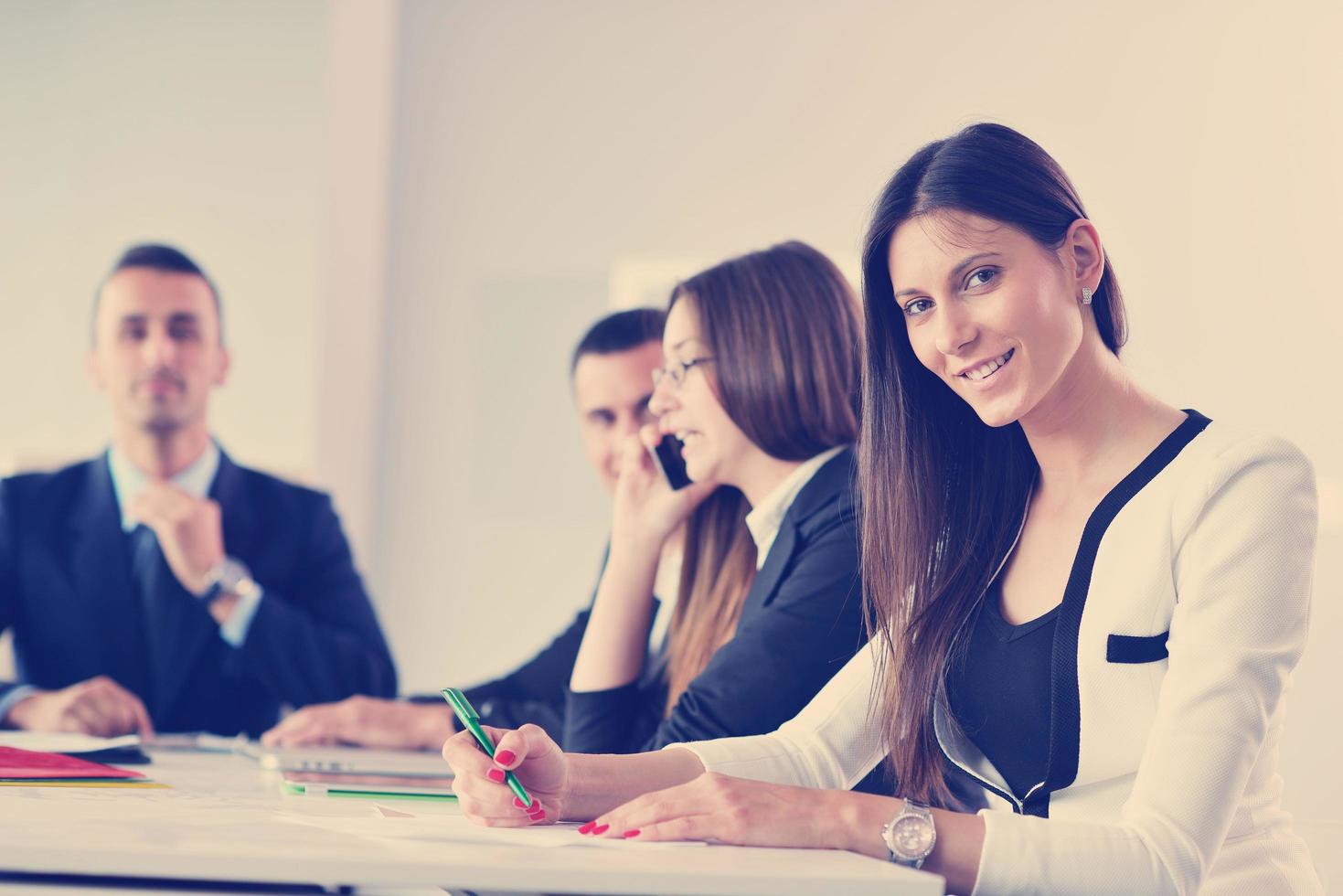 business woman with her staff in background at office photo