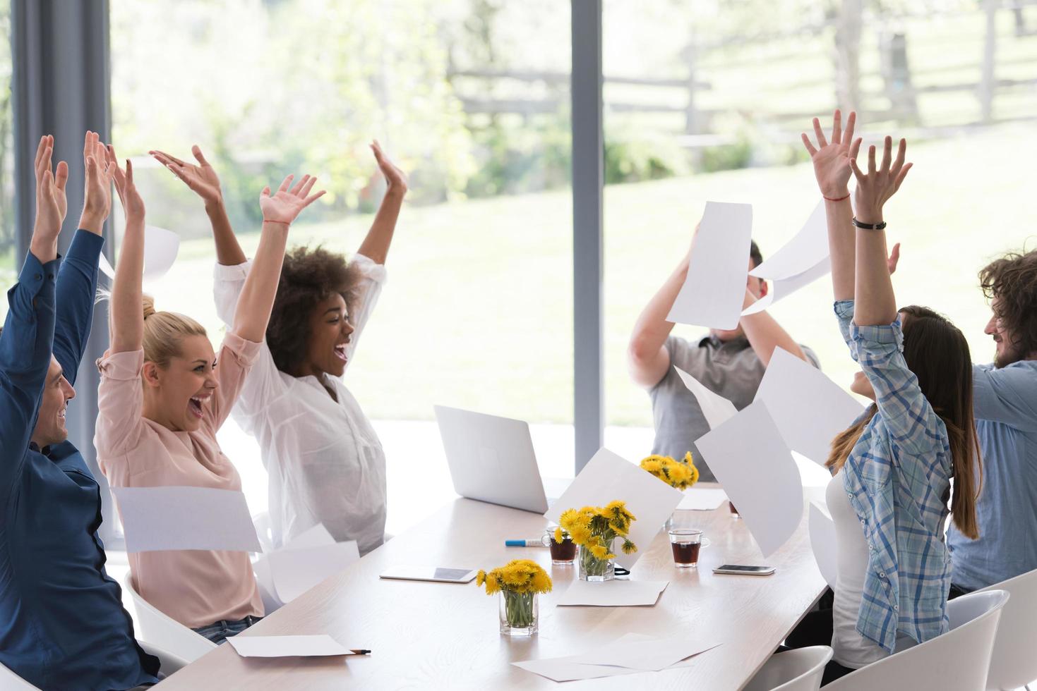 multiethnic startup Group of young business people throwing documents photo