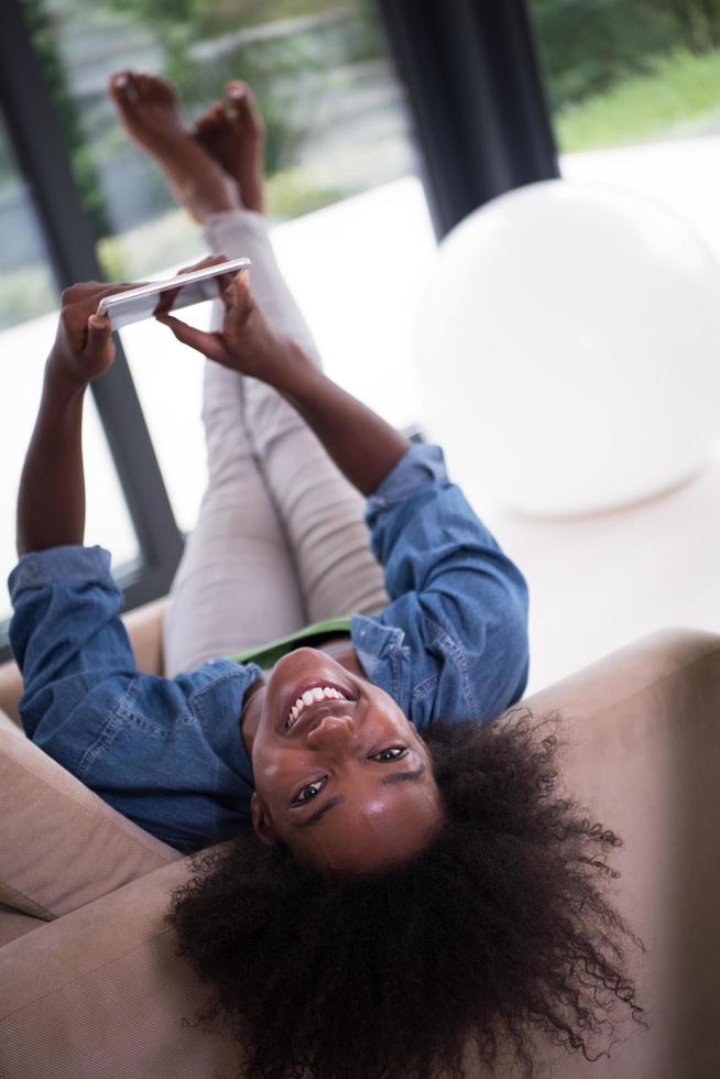 mujer afroamericana en casa con tableta digital foto