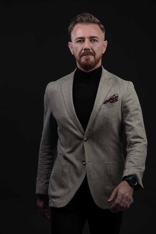 Confident businessman walking forward wearing a causal suit, handsome senior business man hero shot portrait isolated on black photo