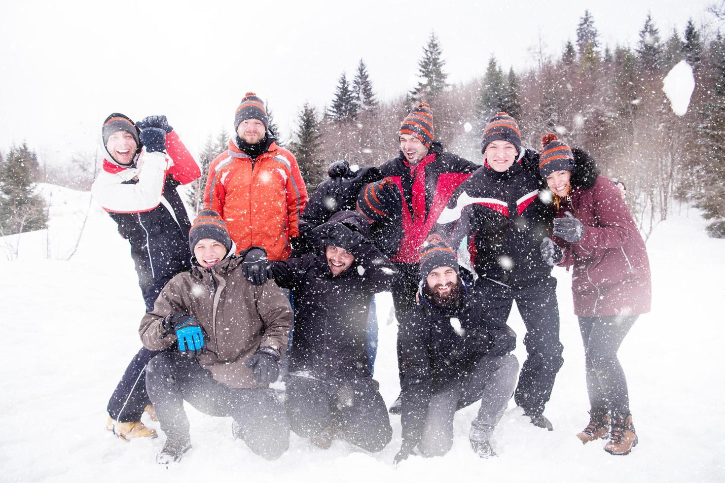 group of young people throwing snow in the air photo