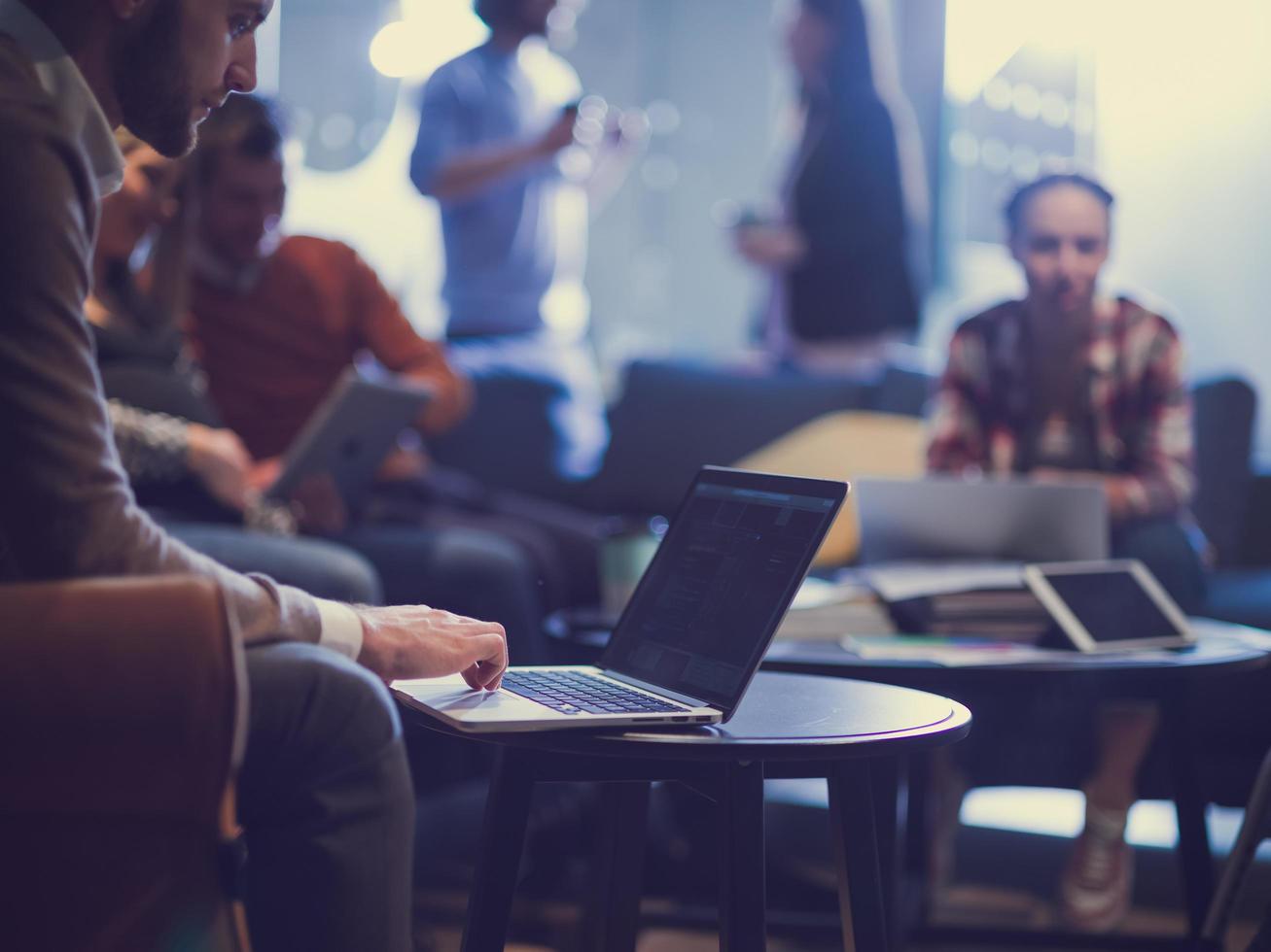 businessman using laptop, concentrated employee analyzing project results, watching webinar or distance staff training photo