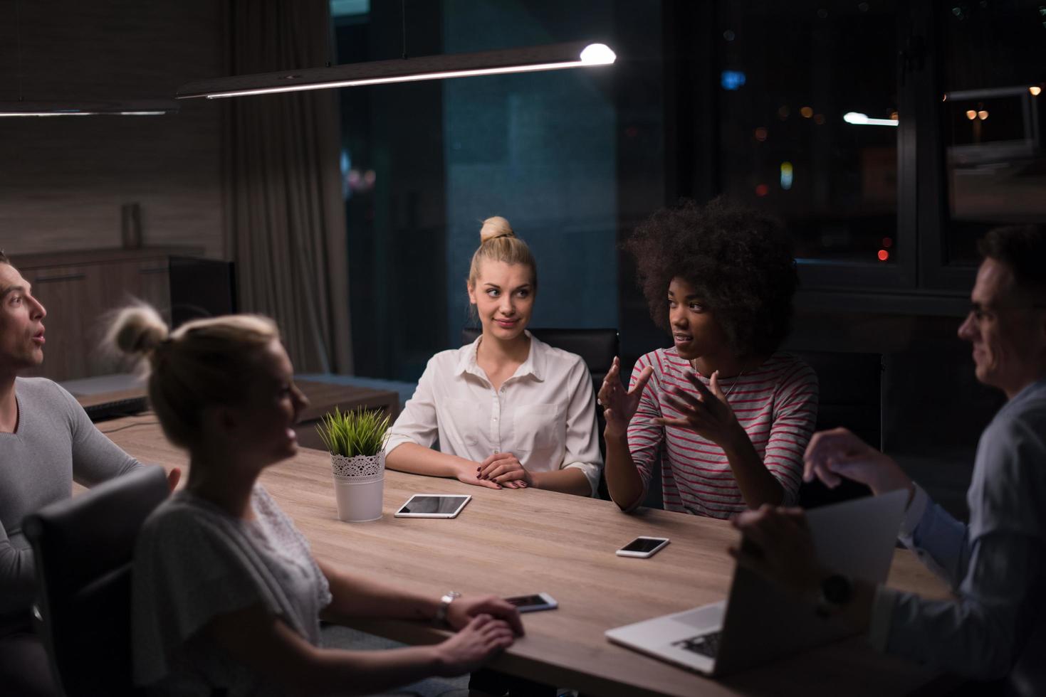 Multiethnic startup business team in night office photo