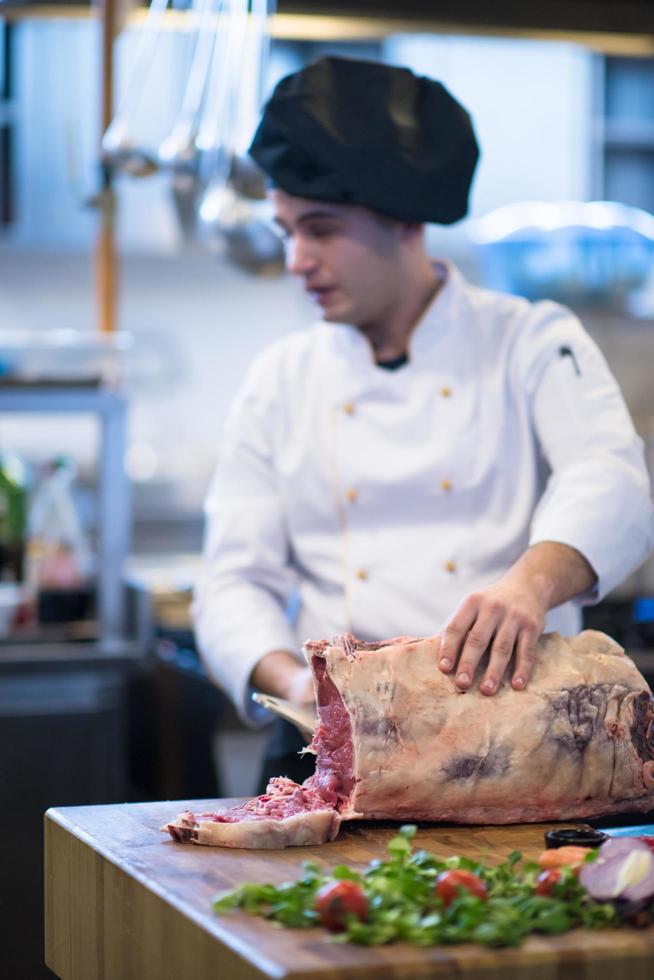 chef cortando un gran trozo de carne foto