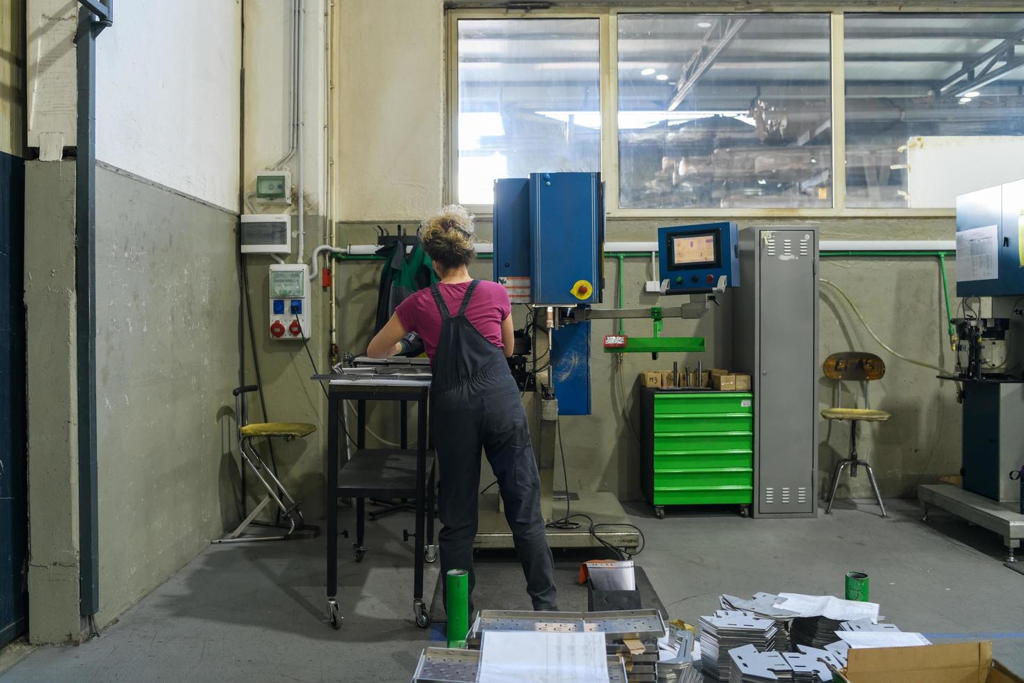 turquía, 2022 - mujer con máscara debido a la pandemia del coronavirus mientras trabaja en la industria metalúrgica moderna y usa taladro foto