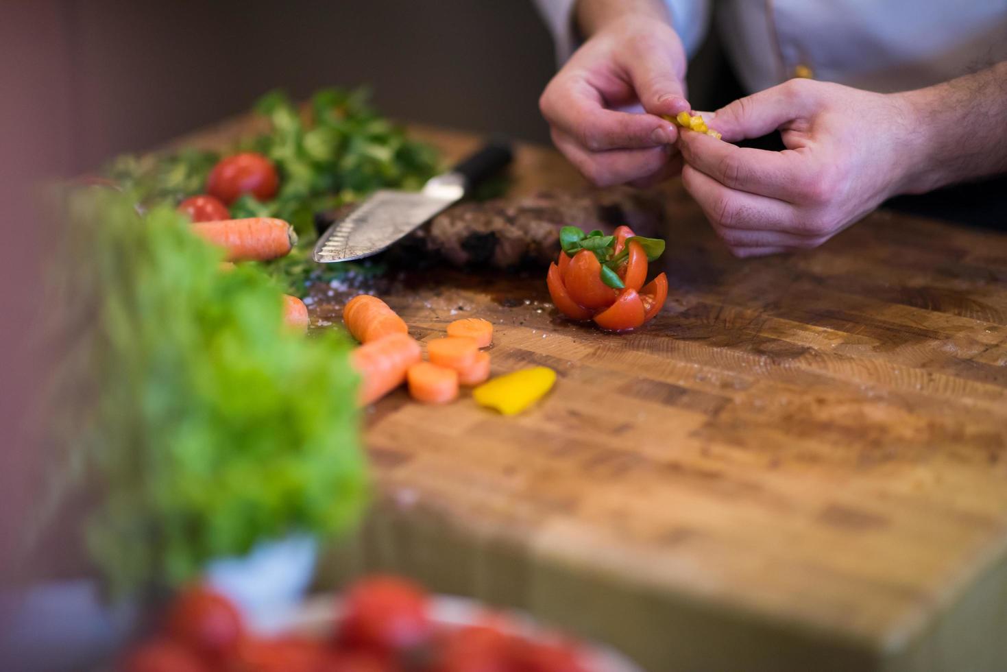 primer plano de las manos del chef preparando bistec de ternera foto