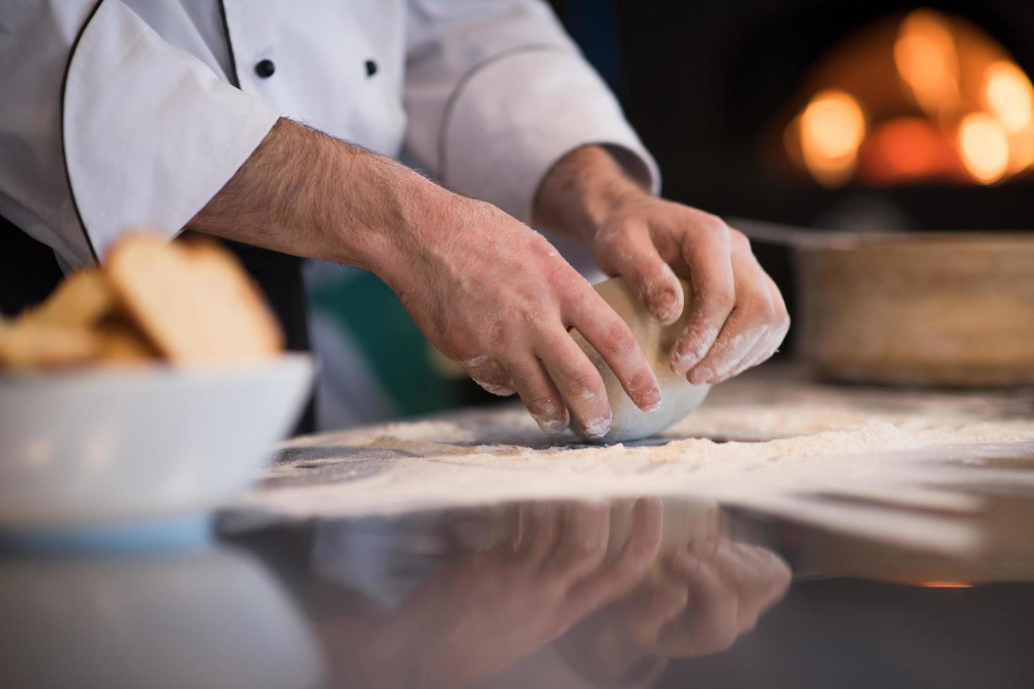 chef hands preparing dough for pizza photo