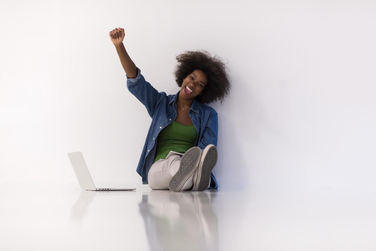 mujer afroamericana sentada en el suelo con una laptop foto