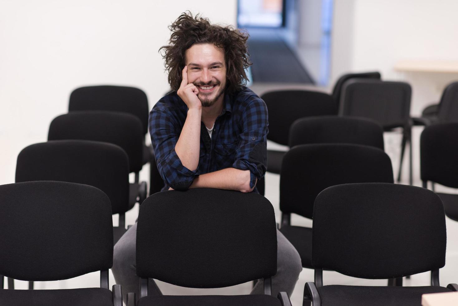 A student sits alone  in a classroom photo