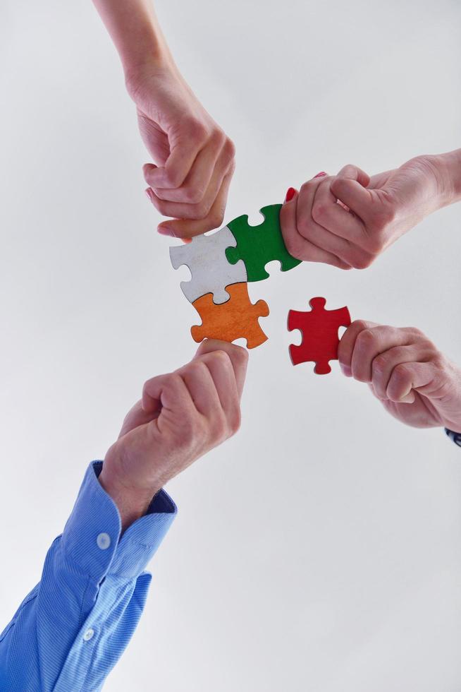Group of business people assembling jigsaw puzzle photo