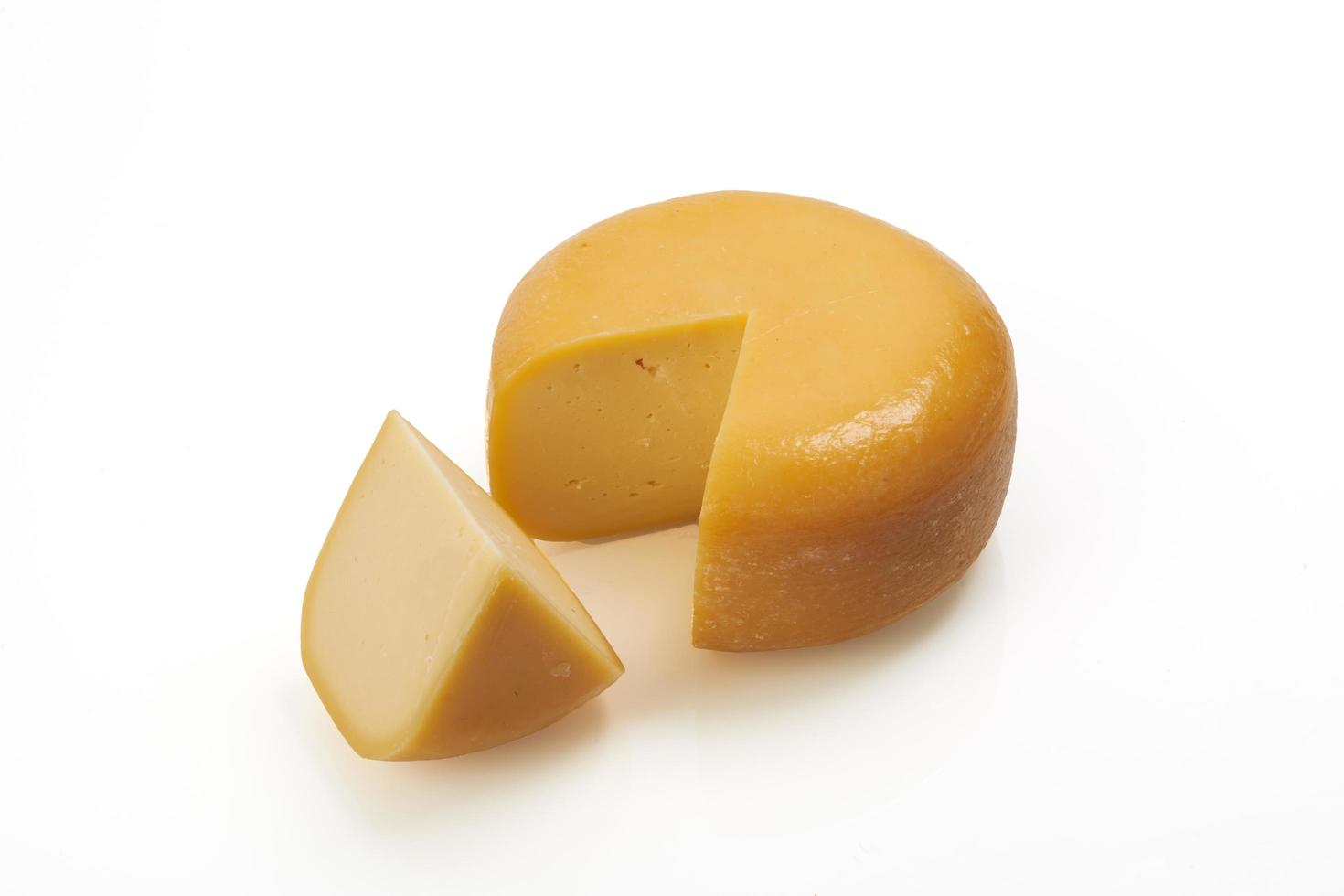 whole round and one peace of organic produced cheese photo