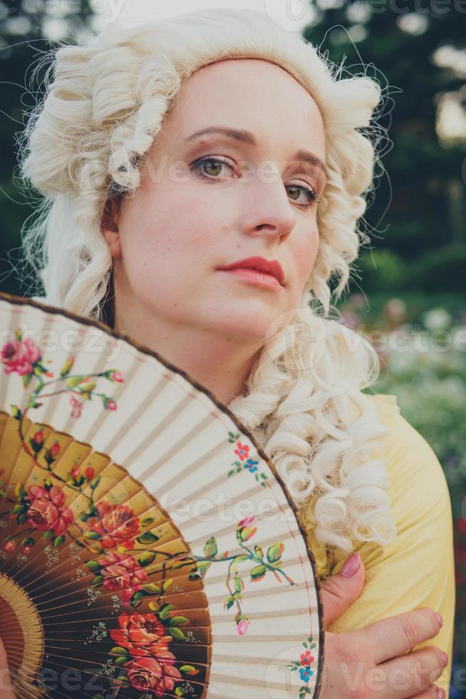 Portrait of blonde woman dressed in historical Baroque clothes with old fashion hairstyle, outdoors. photo