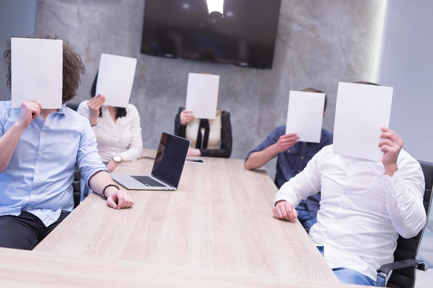 startup business team holding a white paper over face photo