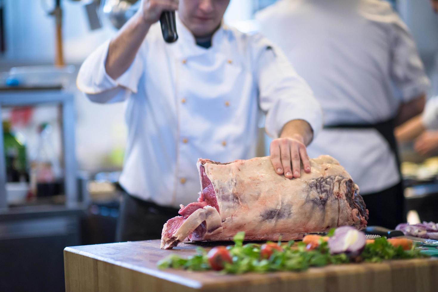 chef cutting big piece of beef photo