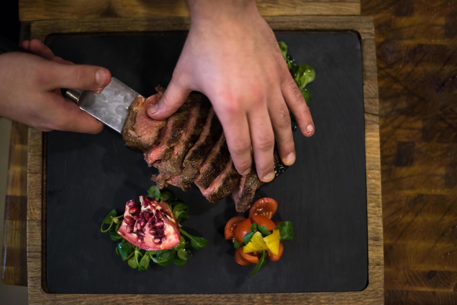 top view of Chef hands serving beef steak photo