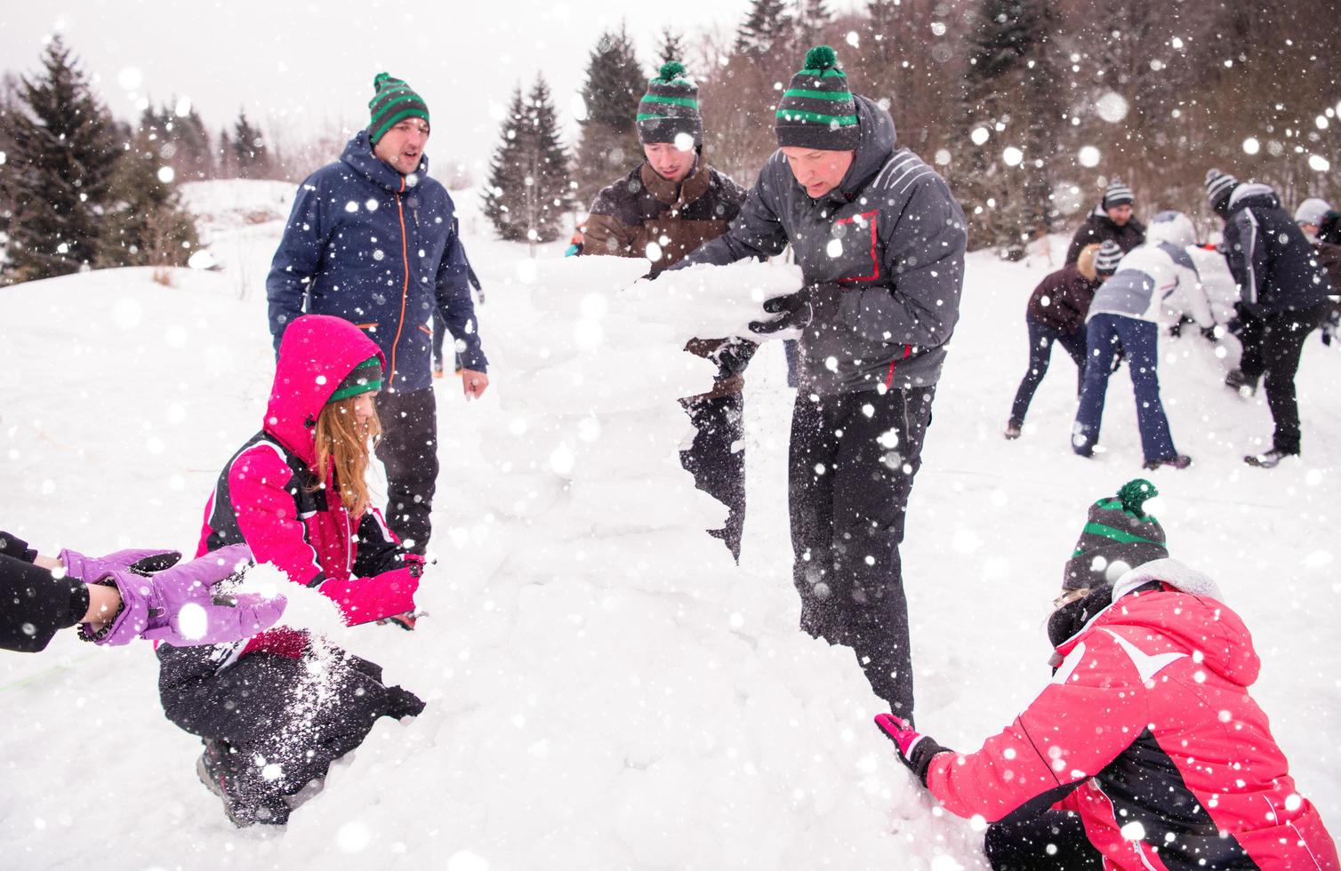 group of young people making a snowman photo