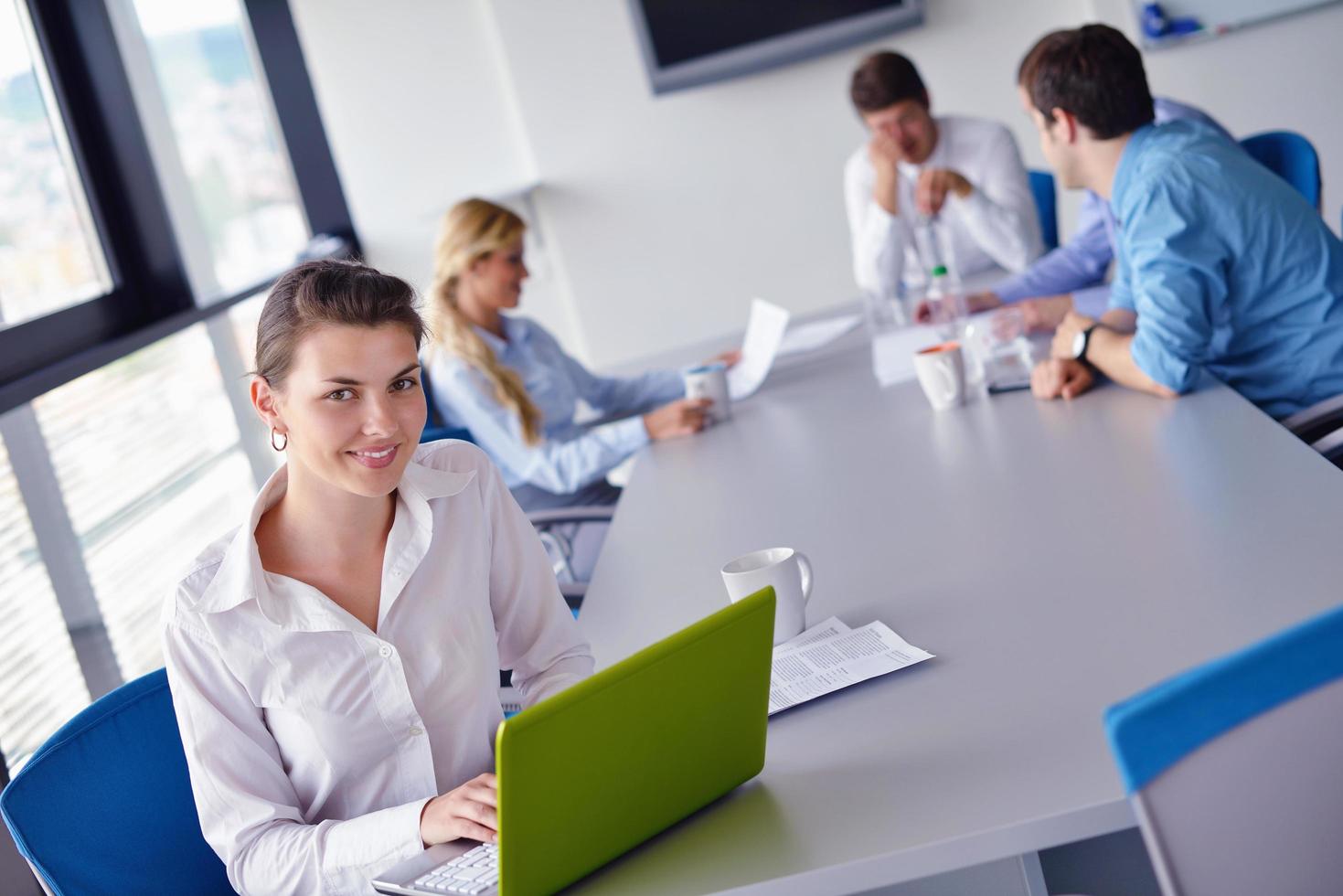 business woman with her staff in background at office photo