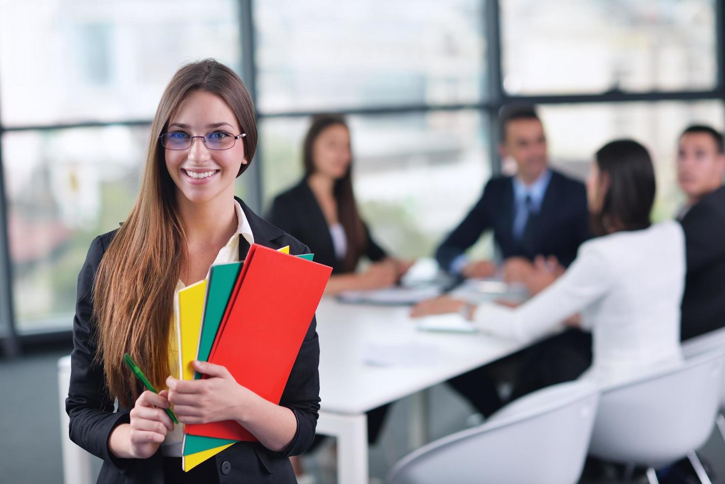 business woman with her staff in background at office photo