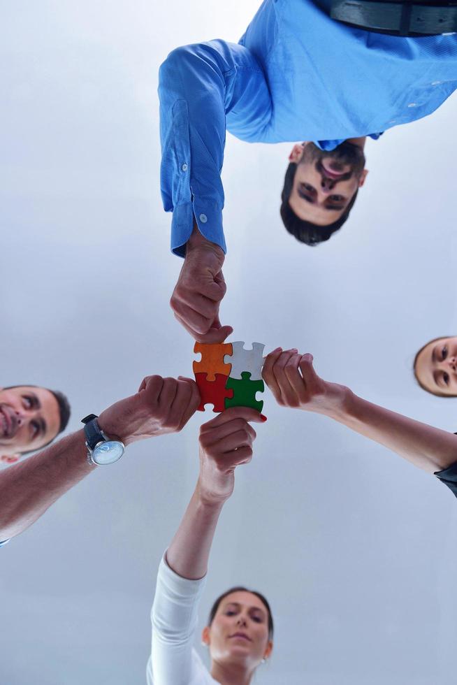 Group of business people assembling jigsaw puzzle photo