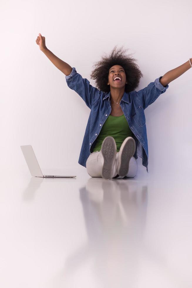 mujer afroamericana sentada en el suelo con una laptop foto