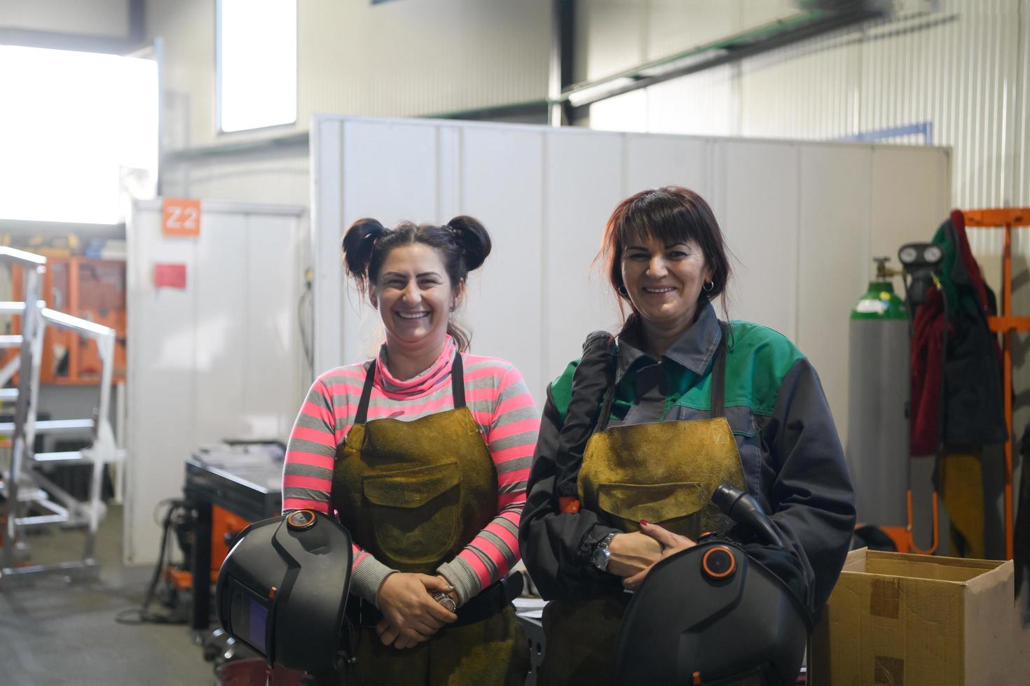 portrait of two welders holding welding masks in their hands and preparing for hard work in a factory photo