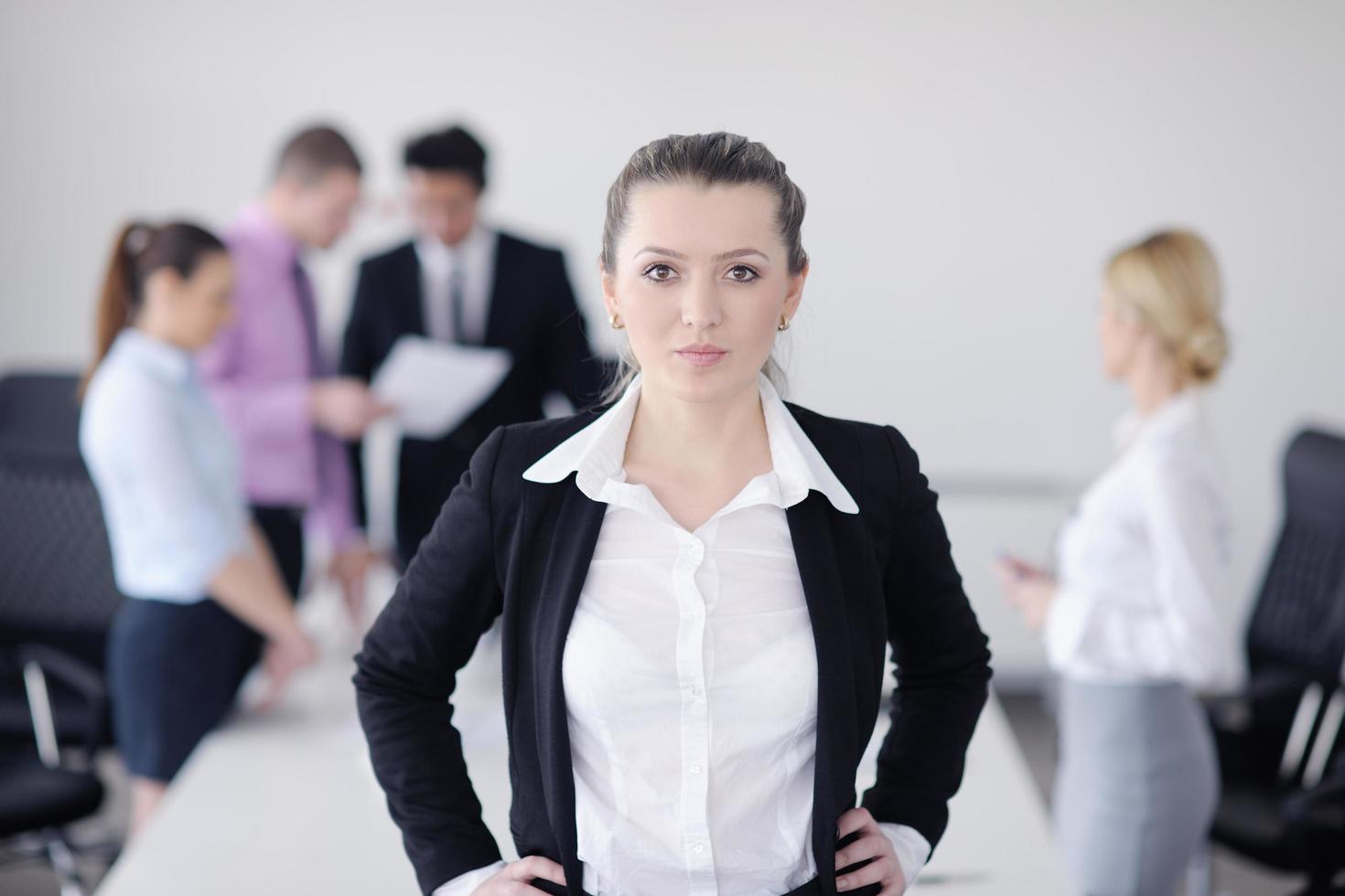 business woman standing with her staff in background photo