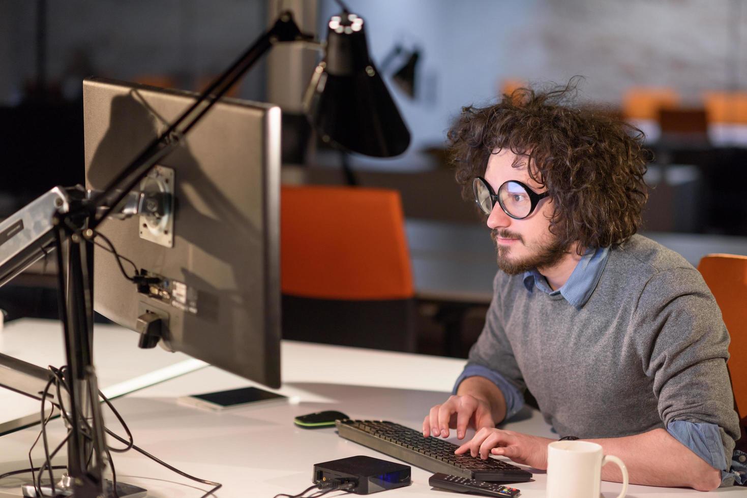 man working on computer in dark startup office photo