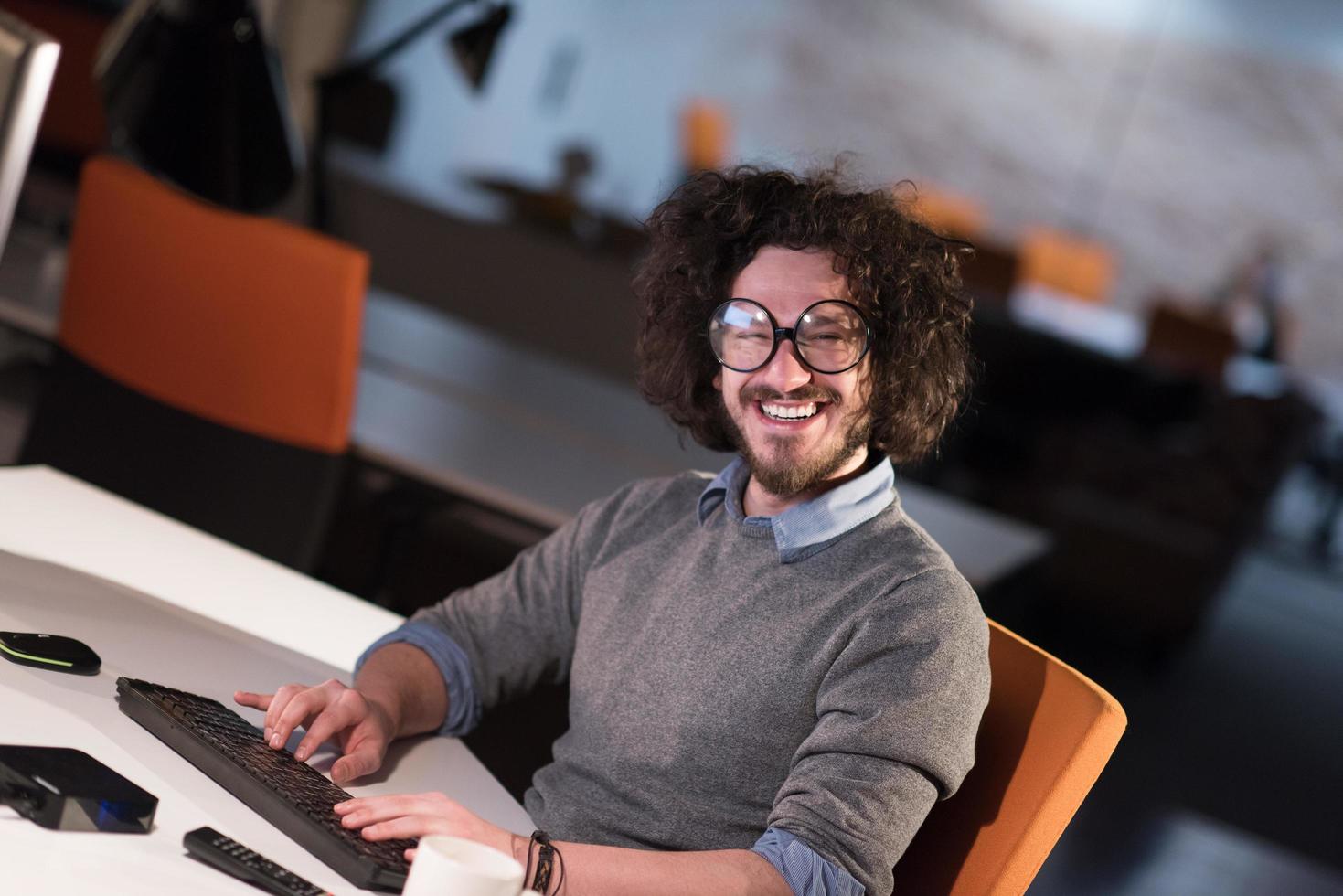 man working on computer in dark startup office photo