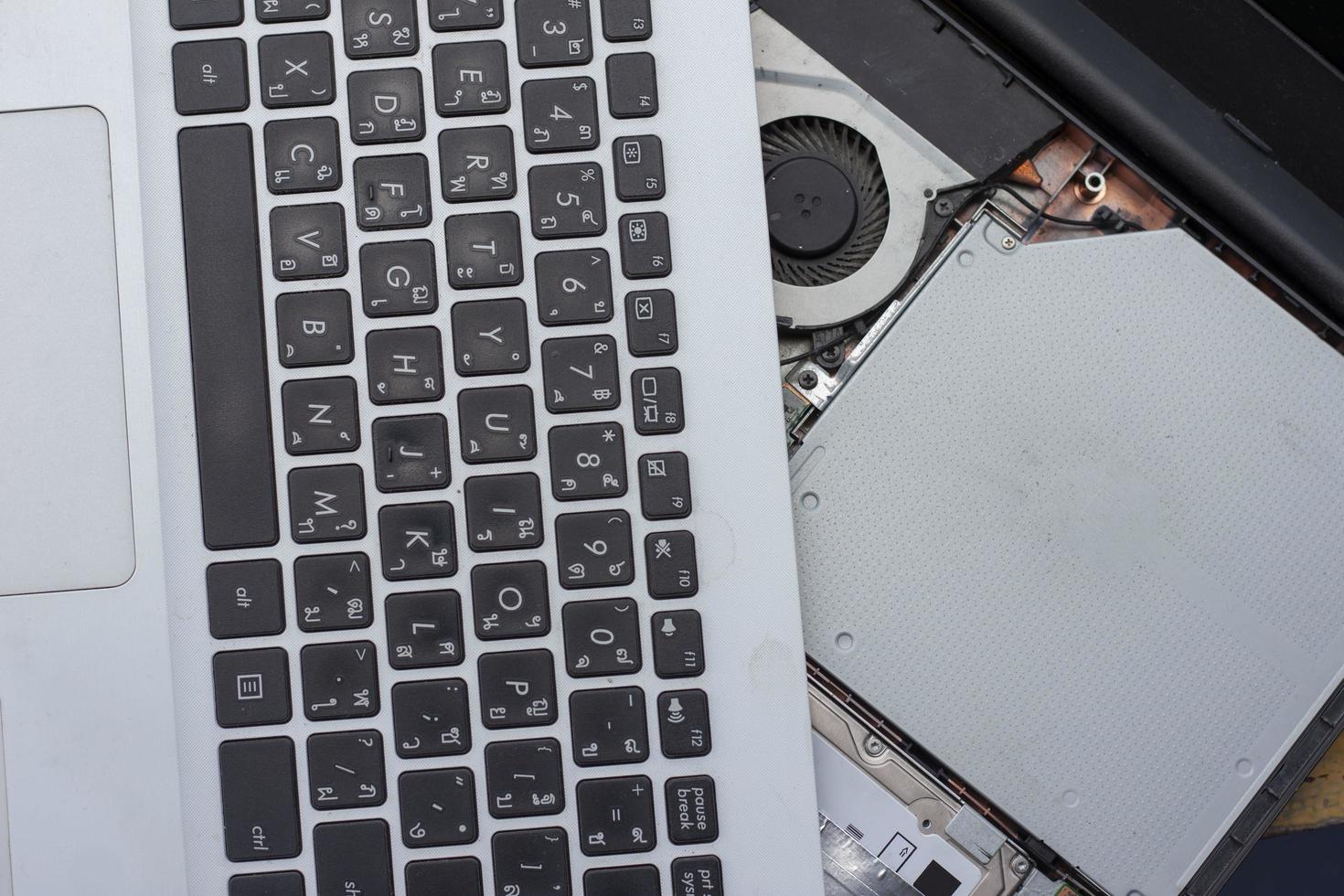 Repair and maintenance laptop computer with Thai keyboard. photo