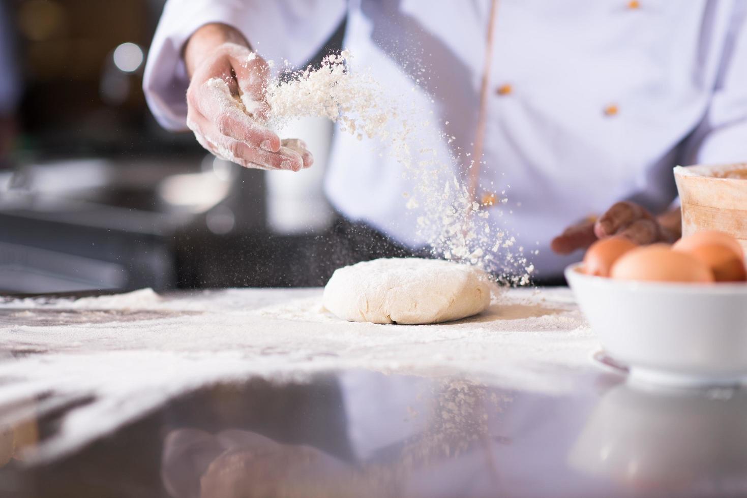 chef hands preparing dough for pizza photo