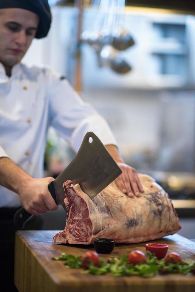 chef cutting big piece of beef photo