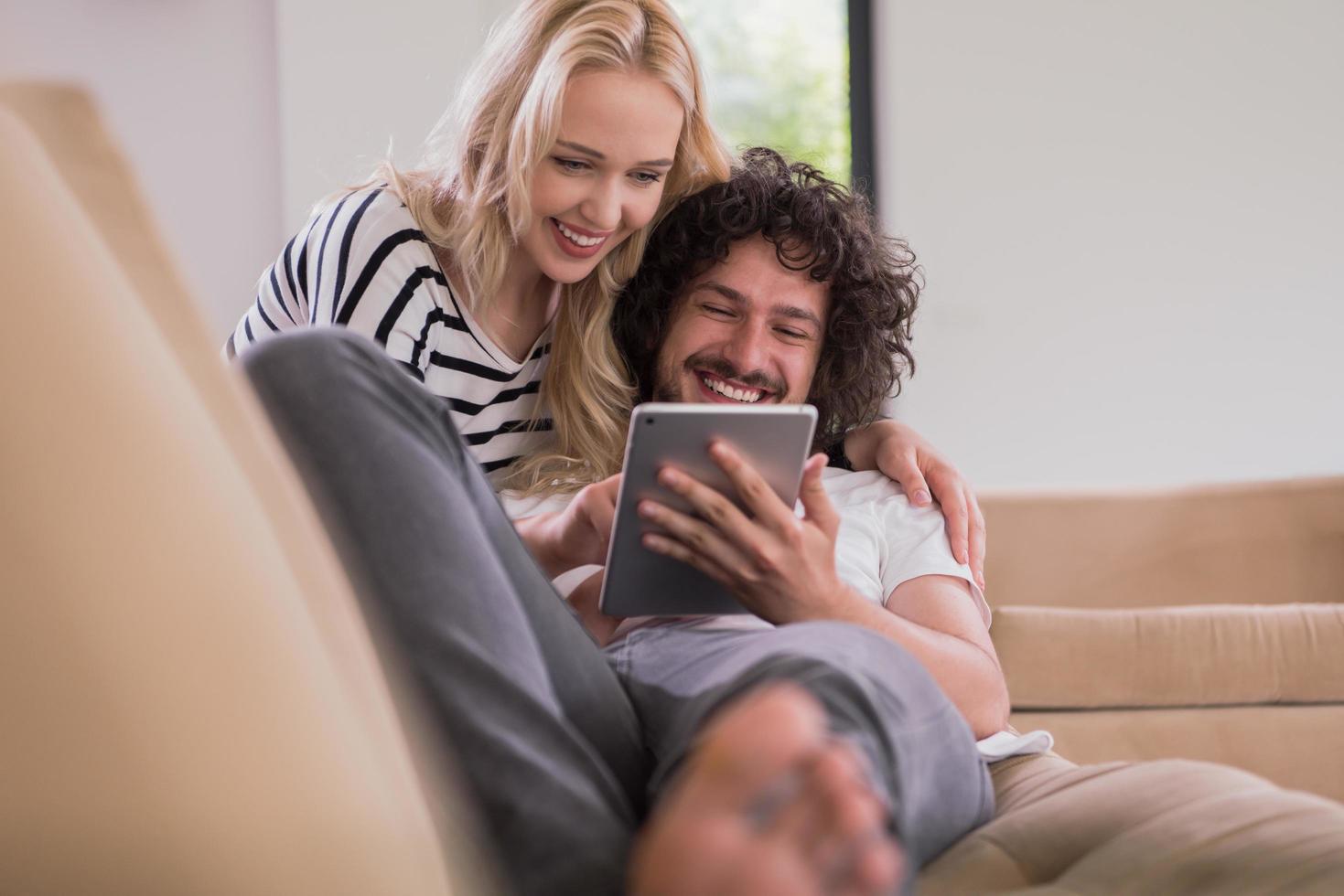 couple relaxing at  home with tablet computers photo