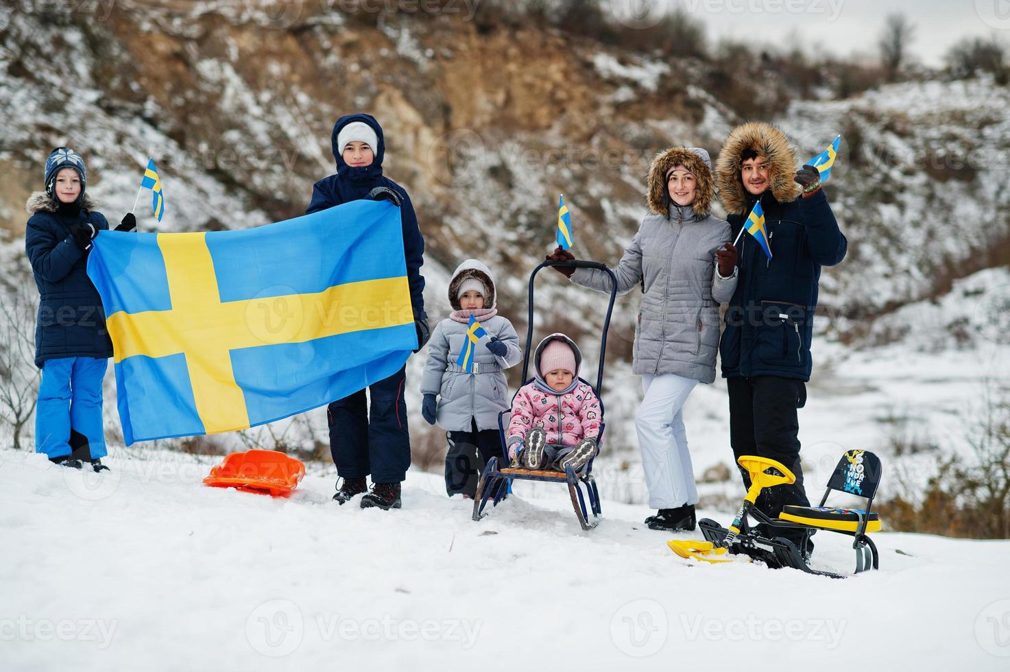 Scandinavian family with Sweden flag in winter swedish landscape. photo
