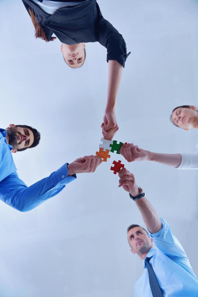 Group of business people assembling jigsaw puzzle photo