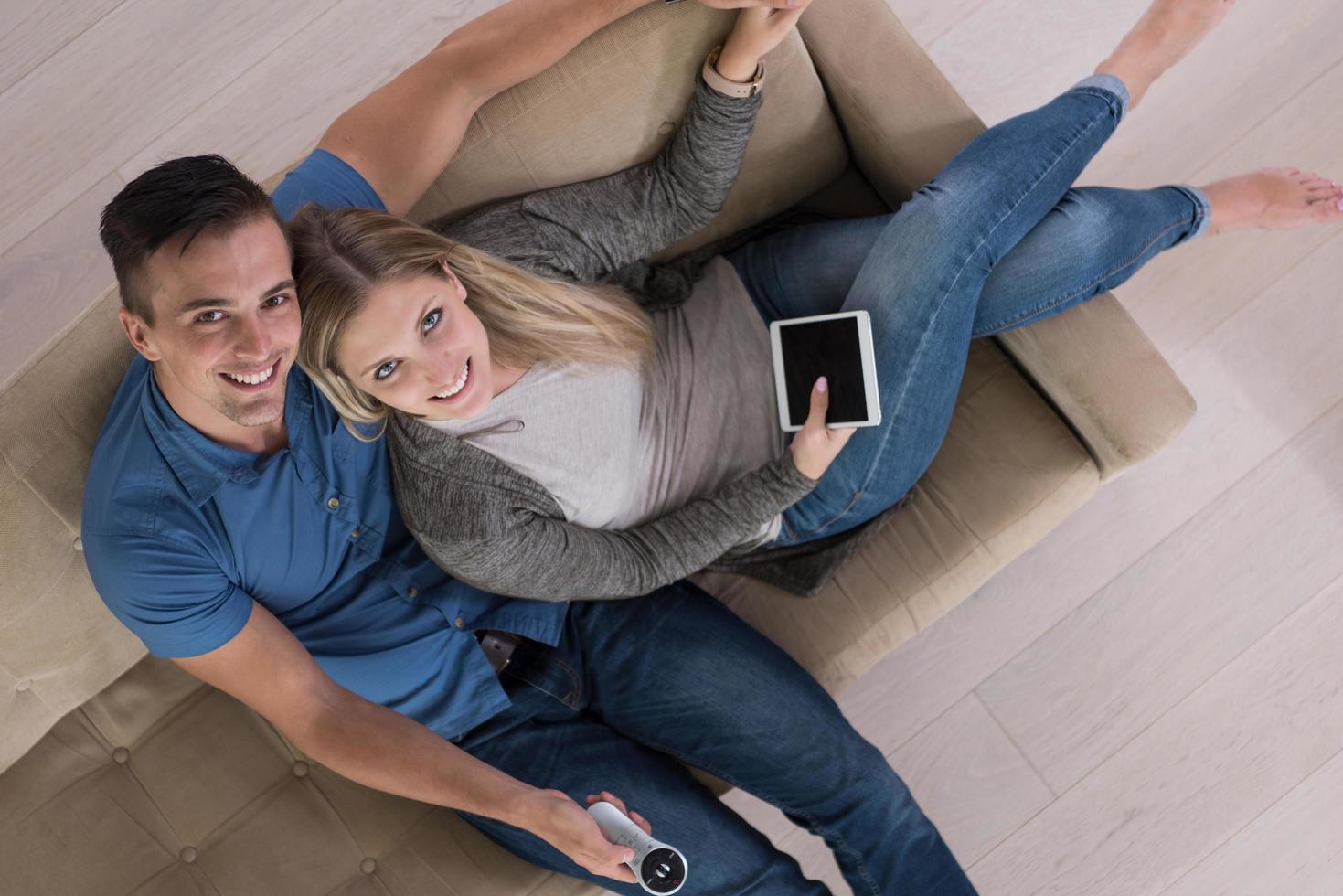 youg couple in living room with tablet top view photo