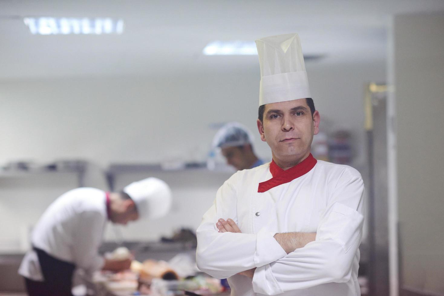 chef en la cocina del hotel preparando y decorando comida foto