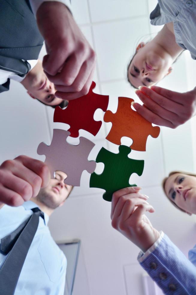 Group of business people assembling jigsaw puzzle photo