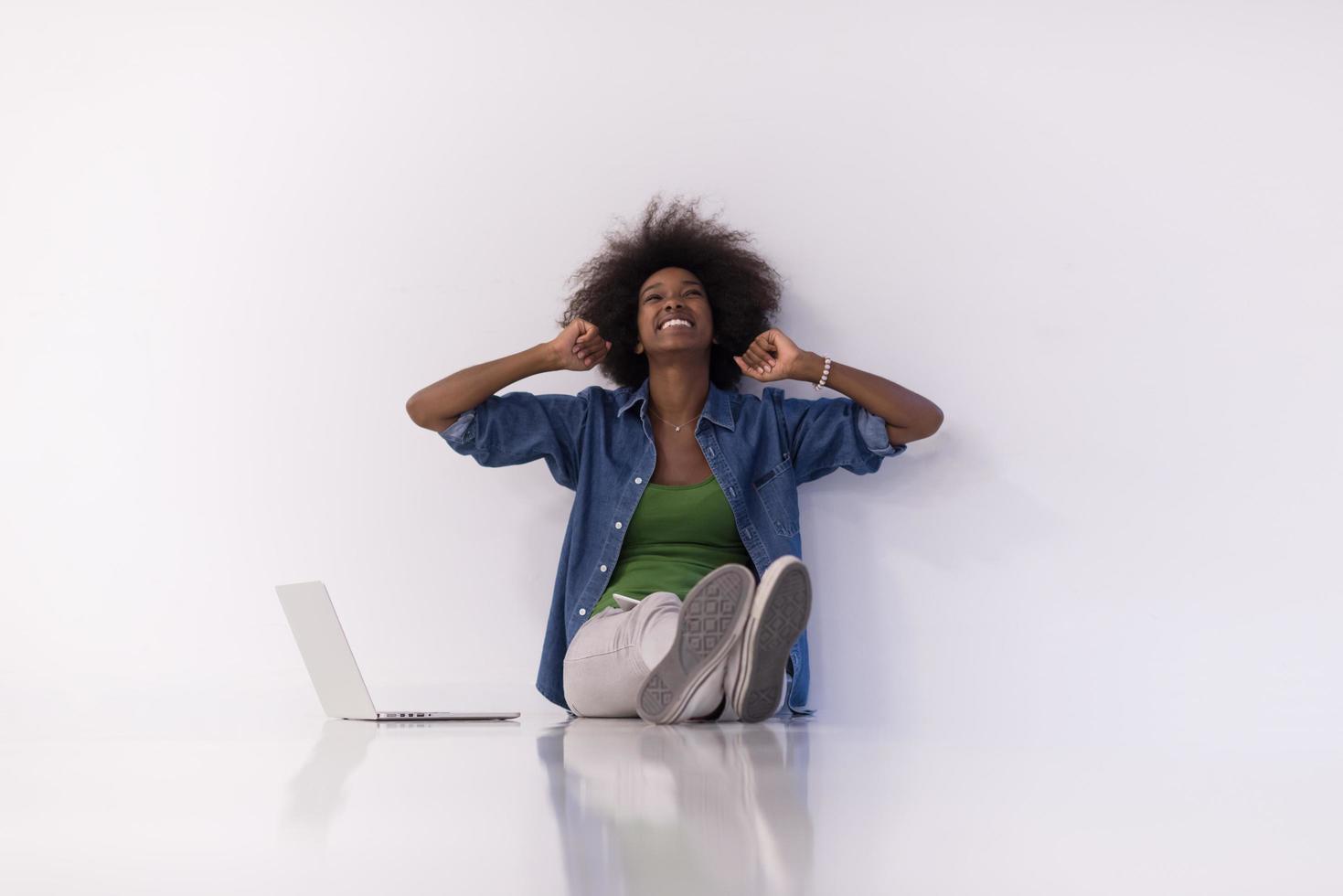 african american woman sitting on floor with laptop photo