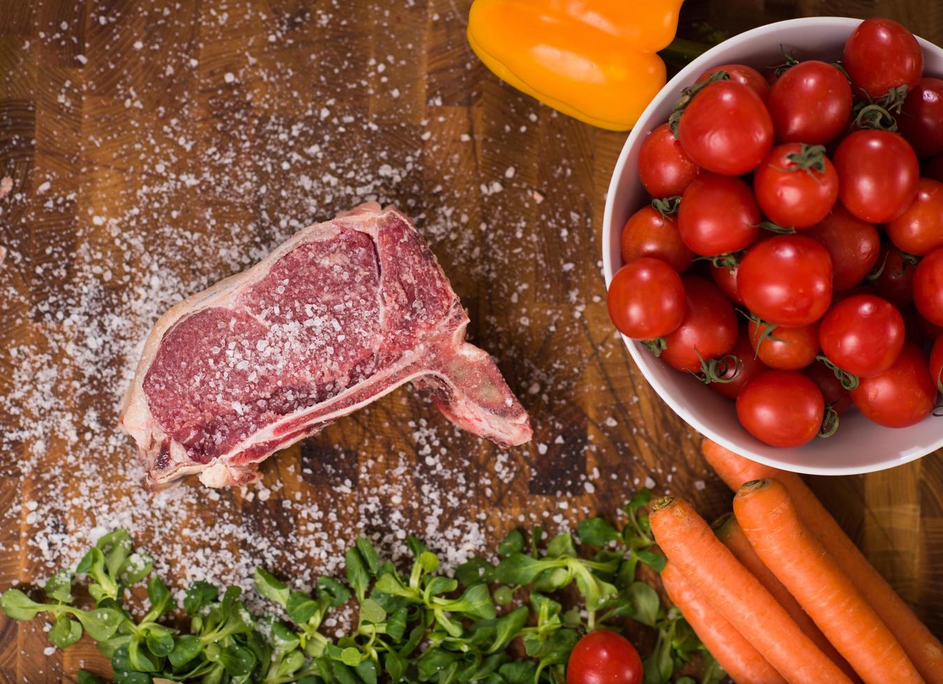 top view of raw steak on wooden table photo