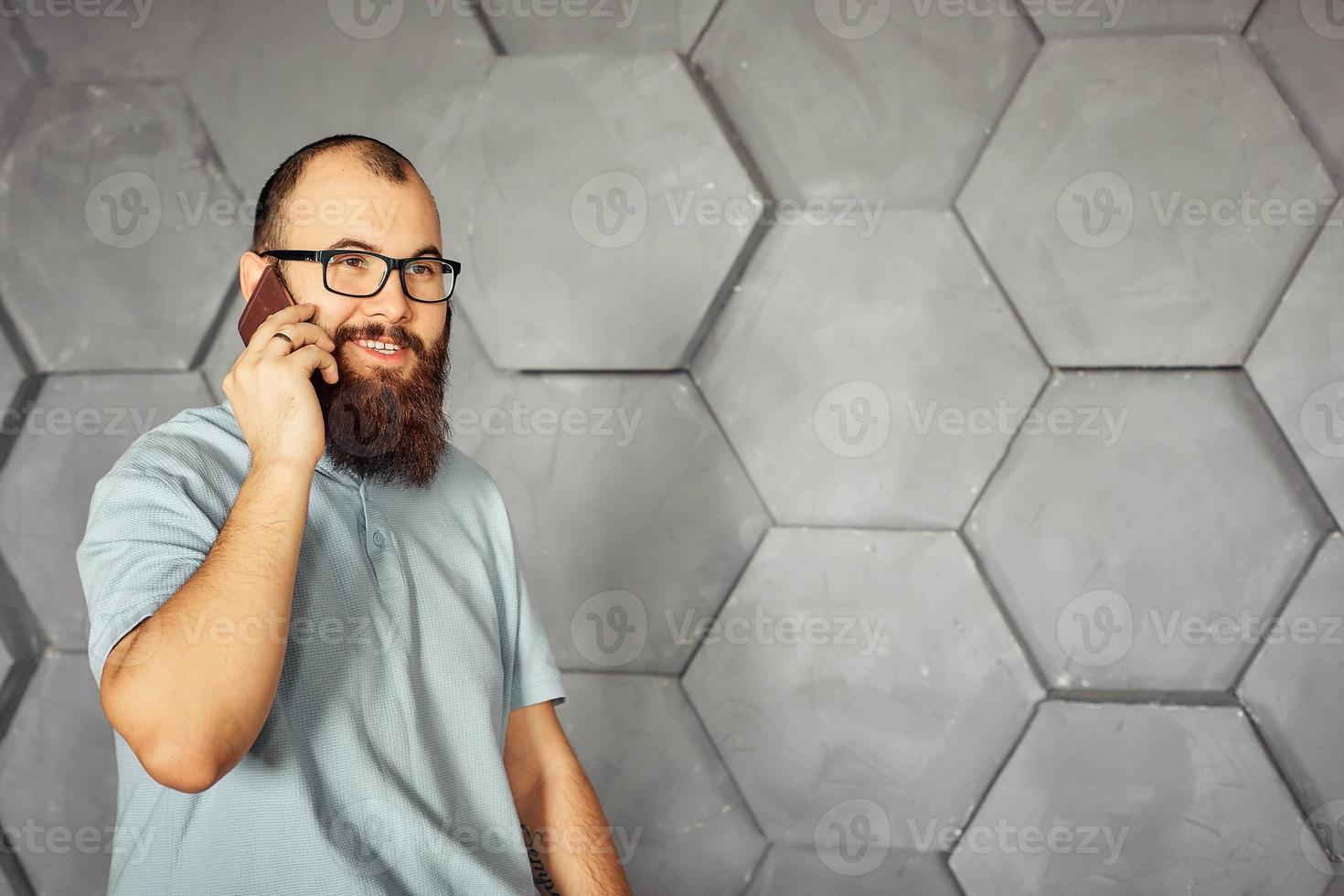 bearded man with glasses talking on a mobile phone photo