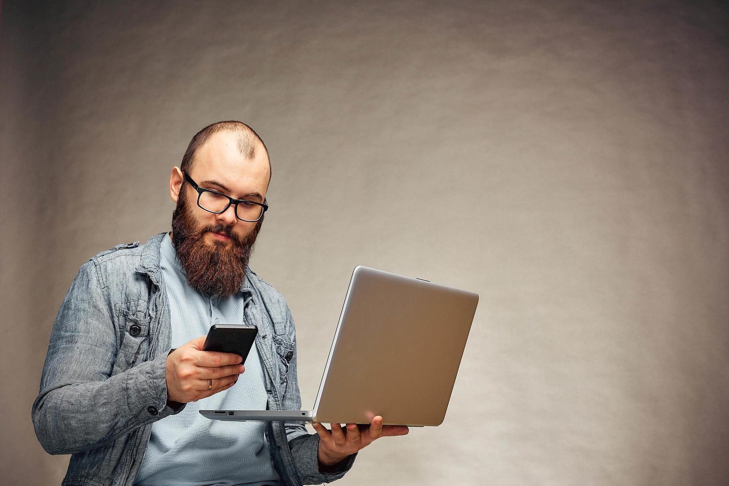 secure online payments. two factor authorization. man hands holding mobile phone and entering password message on laptop photo