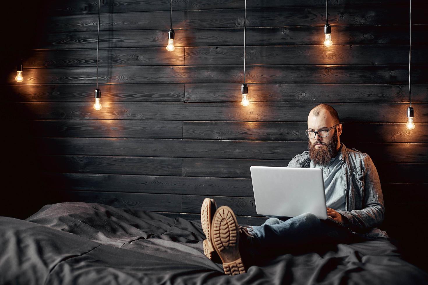 lifestyle successful freelancer man with beard achieves new goal with laptop in loft interior. photo