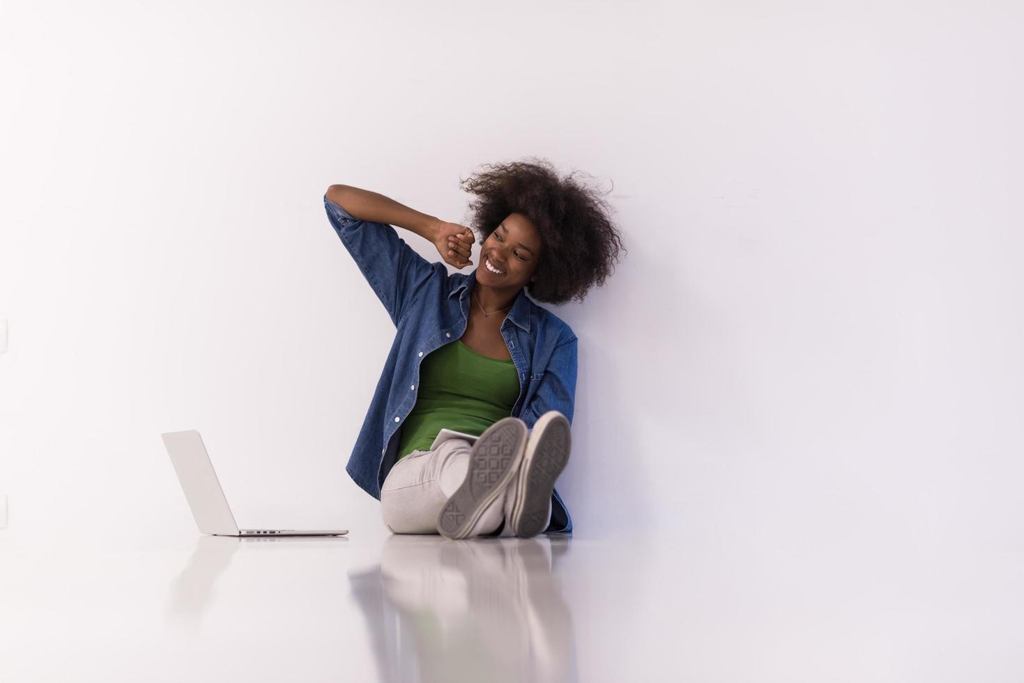 mujer afroamericana sentada en el suelo con una laptop foto