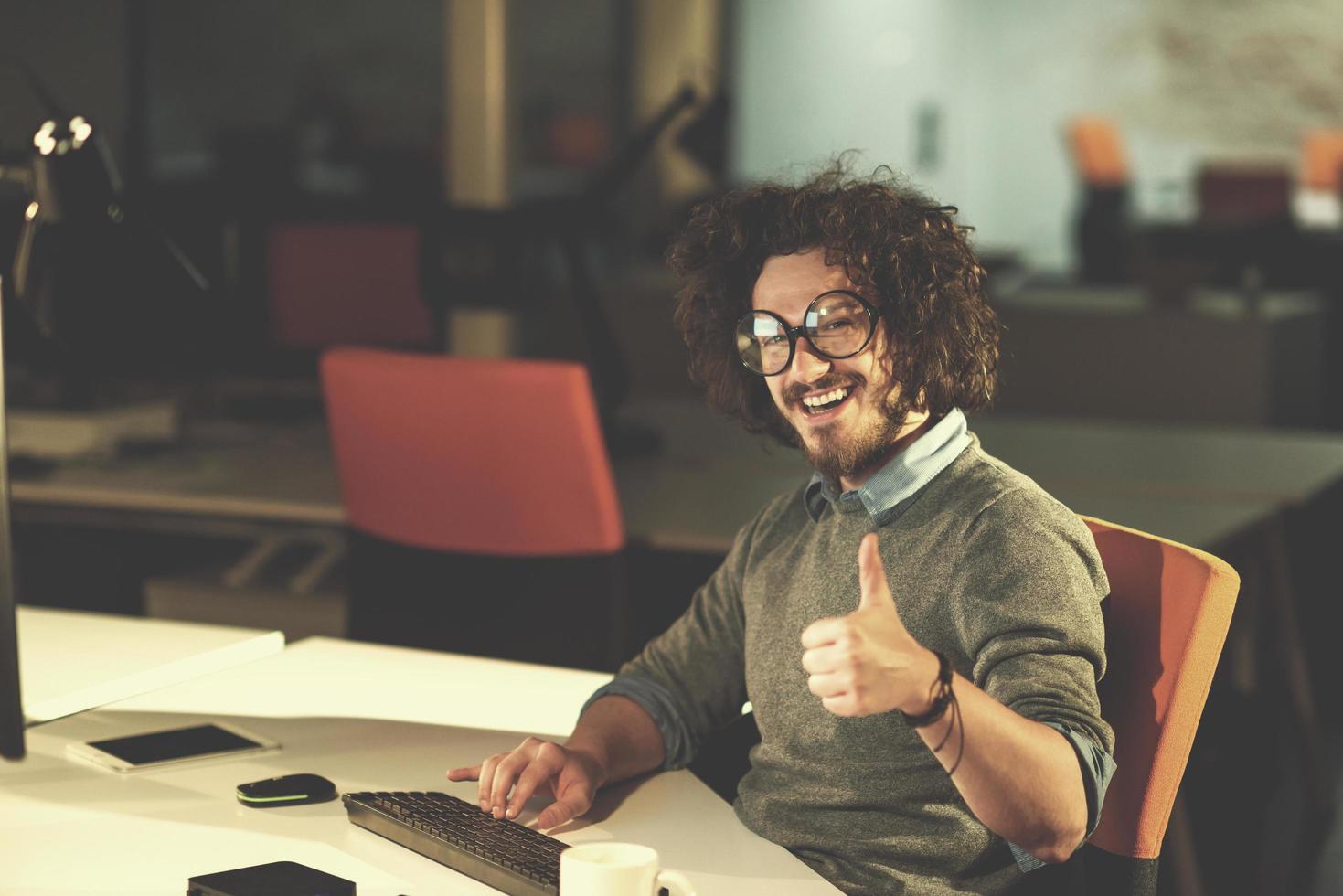 man working on computer in dark startup office photo