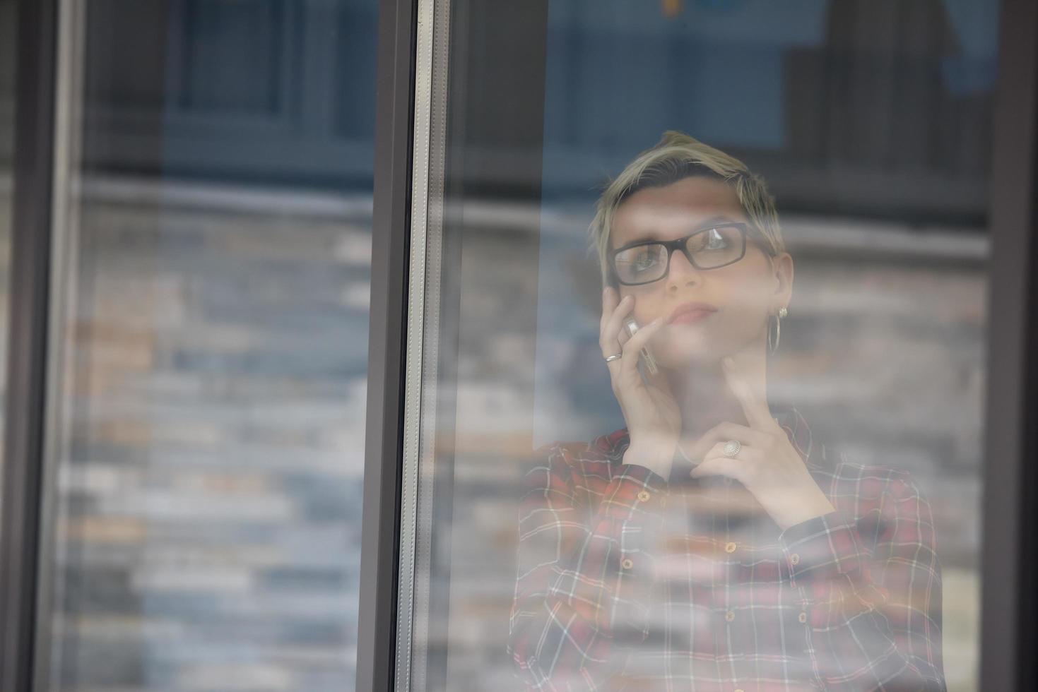business woman at office speaking by phone  team on meeting in background photo